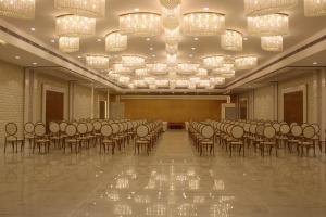 a large room with rows of chairs and chandeliers at Amar Resorrt in Motīhāri +17 photos