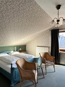 a bedroom with a bed and two chairs and a table at Zum Lahnfelsen Gräveneck in Gräveneck