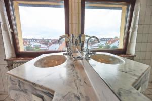 two sinks in a bathroom with two windows at ERCK- Hotel & Gastronomie in Bad Schonborn +59 photos