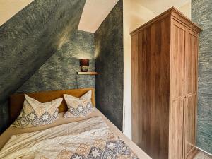a bedroom with a bed and a wooden cabinet at Brockmann, Ferienidylle in Neuenkirchen +99 photos