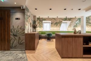 a lobby with a counter and plants on the wall at Dolce Vita Hotel Art in Budapest