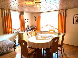 a dining room with a table and chairs and windows at An-der-Stadtmauer in Fladungen +12 photos