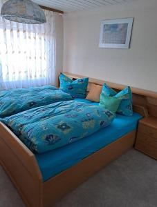 a bed with a blue comforter and pillows on it at An-der-Stadtmauer in Fladungen