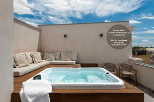 a jacuzzi tub on a balcony with a couch at La Sillería de Arfe in Seville