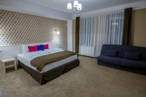 Un dormitorio con una cama y un sofá azul. en French Boutique, en Brasov