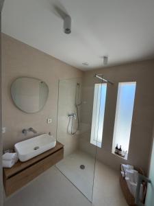 a bathroom with a tub and a sink and a mirror at Villa Čapula - Modern Apartment with Sea View and Parking, Marušići in Omiš +13 photos
