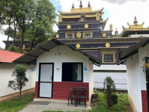 a house with two chairs in front of a building at Dakshinkali & Dollu Resort in Pharping