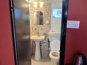 a small bathroom with a toilet and a sink at Dakshinkali & Dollu Resort in Pharping