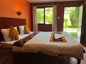 a bedroom with a large bed and a window at Dakshinkali & Dollu Resort in Pharping