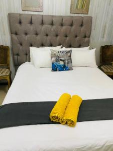 a large bed with two yellow towels on it at B Cubed Lodge in Port Shepstone +41 photos