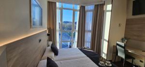 a hotel room with a bed and a large window at Hotel Nueva Plaza in Maliaño