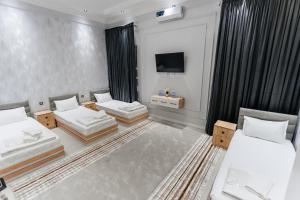 a hotel room with two beds and a television at Classic Hotel Samarkand in Samarkand