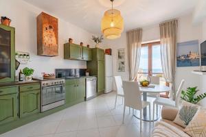 a kitchen with green cabinets and a table with chairs at Casa della Civetta in Monopoli