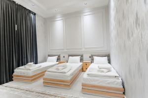 two beds in a room with white walls at Classic Hotel Samarkand in Samarkand +22 photos