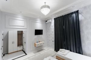 a white room with a bed and a television at Classic Hotel Samarkand in Samarkand