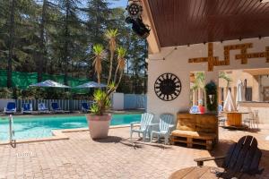 a patio with a pool and chairs and a clock at Résidence Torre Del Far in Tautavel +13 photos