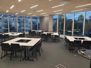 a conference room with tables and chairs and windows at Place Lund in Lund