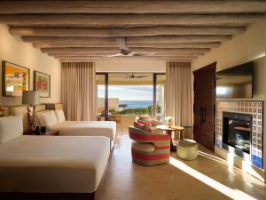 a living room with a couch and a fireplace at Waldorf Astoria Los Cabos Pedregal in Cabo San Lucas