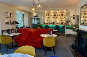 a restaurant with red chairs and tables and a bar at Royal Sportsman Hotel in Porthmadog