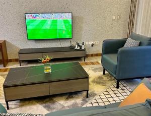 a living room with a tv and a coffee table at KiGALI CITY COMFORT ACCOMMODATION in Kigali