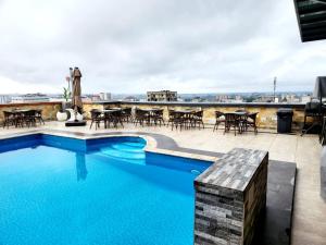 a swimming pool with tables and chairs on a roof at Borelie Guest House in Douala