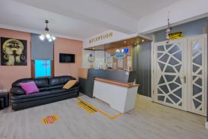 a living room with a black leather couch and a door at Otel DENİZYILDIZI CENTRUM in Fethiye