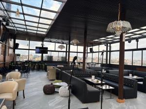 a restaurant with couches and tables and windows at Borelie Guest House in Douala