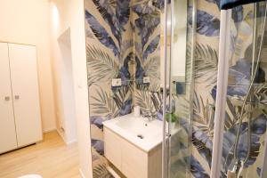 a bathroom with a sink and blue and green wallpaper at Penelope's House in Otranto in Otranto