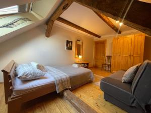 a bedroom with a bed and a couch in a room at Viesu nams "Vijās" in Degumuiža
