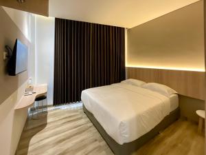 a hotel room with a bed and a television at Oemah Djari Hotel Syariah Salatiga in Salatiga +13 photos