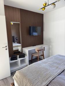 a bedroom with a bed and a desk and a mirror at Lütte Lina in Neuenkirchen