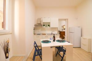 a white kitchen with a table and two chairs at Penelope's House in Otranto in Otranto