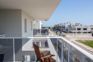 a balcony with a chair and a view of a street at AT Ponent II B3 in Oliva