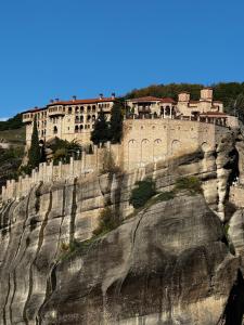 ein Gebäude an einem Berghang in der Unterkunft Meteora Mandras House in Kalambaka