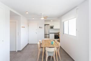 a kitchen and dining room with a table and chairs at AT Ponent II B3 in Oliva