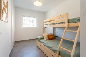 a bedroom with two bunk beds and a ladder at AT Ponent II B3 in Oliva +13 photos