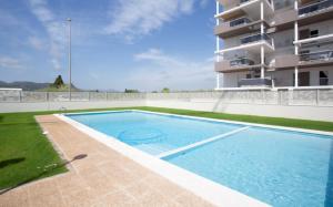 a swimming pool in front of a building at AT Ponent II B3 in Oliva
