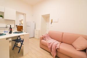 a living room with a pink couch and a kitchen at Penelope's House in Otranto in Otranto +23 photos