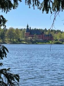 a view of a large house from across a lake at Annehill i Bro in Bro