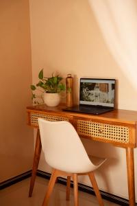 a laptop computer sitting on a wooden desk with a white chair at Bakamuna Villa in Dickwella +49 photos