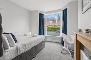 a bedroom with a bed and a window at 5-Bed Family & Group Stay Near Cricket Ground in Worcester