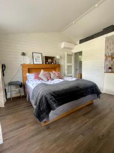a bedroom with a large bed with pink pillows at Annehill i Bro in Bro