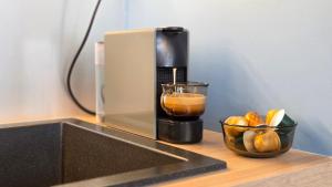 a coffee maker on a counter next to a bowl of fruit at Antresola - Apartamenty Parkowe in Gniezno +16 photos