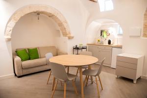 a kitchen and living room with a table and a couch at Trullo Fico d'India in Alberobello