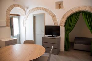 a living room with a table and a tv at Trullo Fico d'India in Alberobello