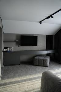 a living room with a flat screen tv on a wall at Gloria Hotel in Szack