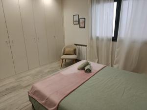 a bedroom with a large bed and a chair at Bella Lucía in Lloret de Mar