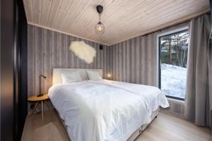 a bedroom with a large white bed and a window at Lakelodge 10p in Vradal