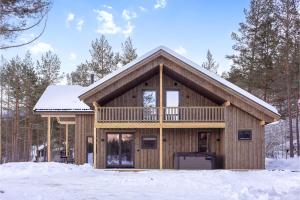 a log cabin with a balcony in the snow at Lakelodge 10p in Vradal