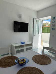 a table with two chairs and a bowl of fruit on it at Perla Bianca Holiday Home, Forio in Forio d'Ischia